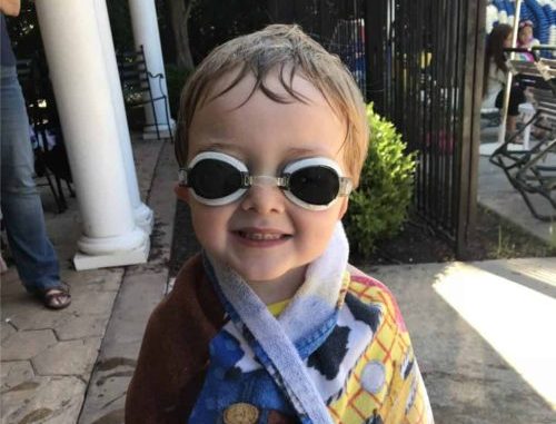 Image of boy in towel and goggles at pool for summer survival