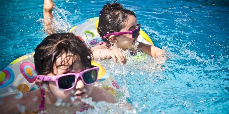 two little girls going to the pool and swimming