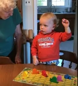 3 year old playing the best board game snail game with grandmother