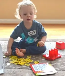 2 or 3 year old boy playing a Zingo board game