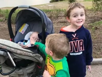 a toddler, preschooler, and a 1 month old baby on a walk